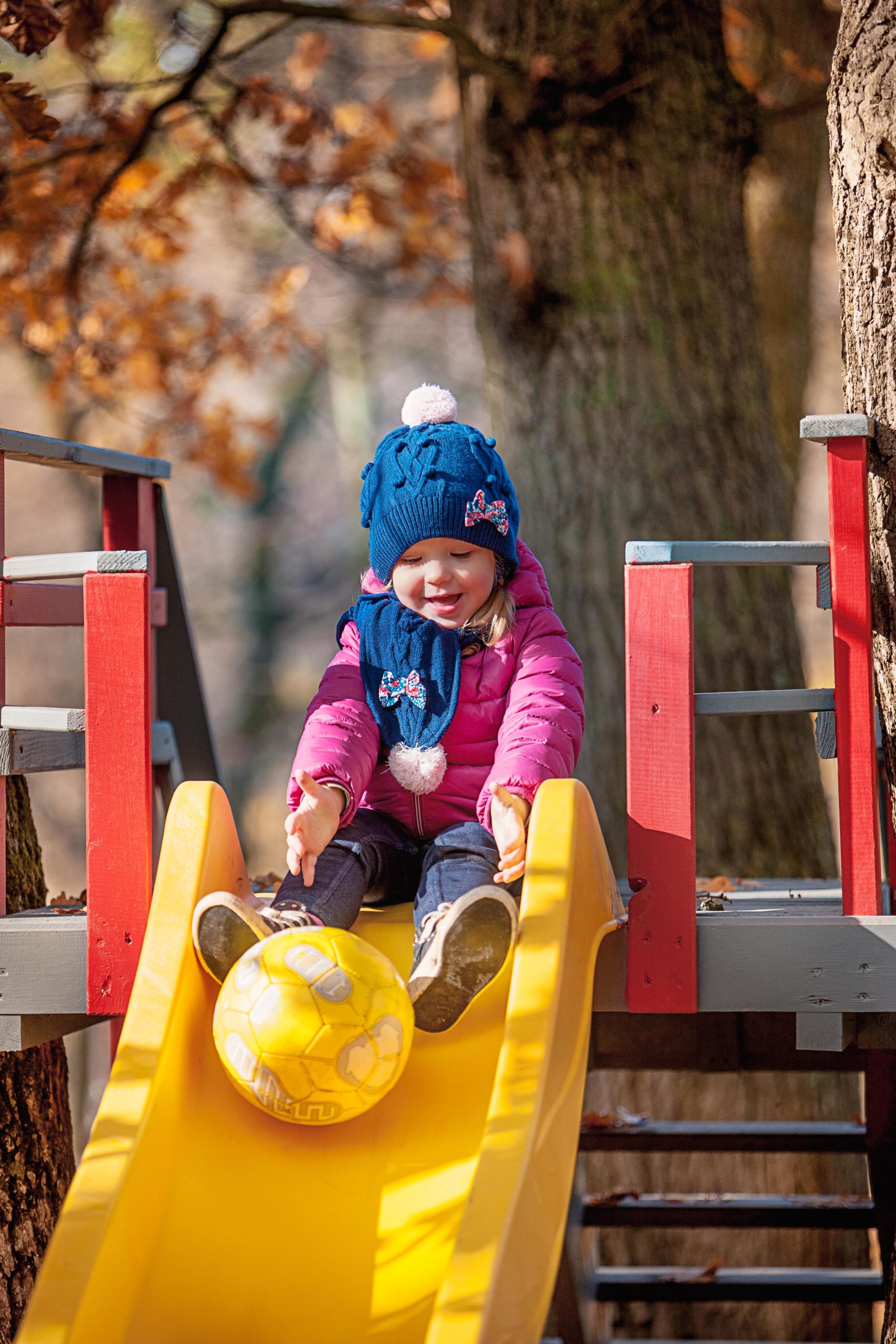 happy-three-year-baby-girl-jacket-slide-park-min