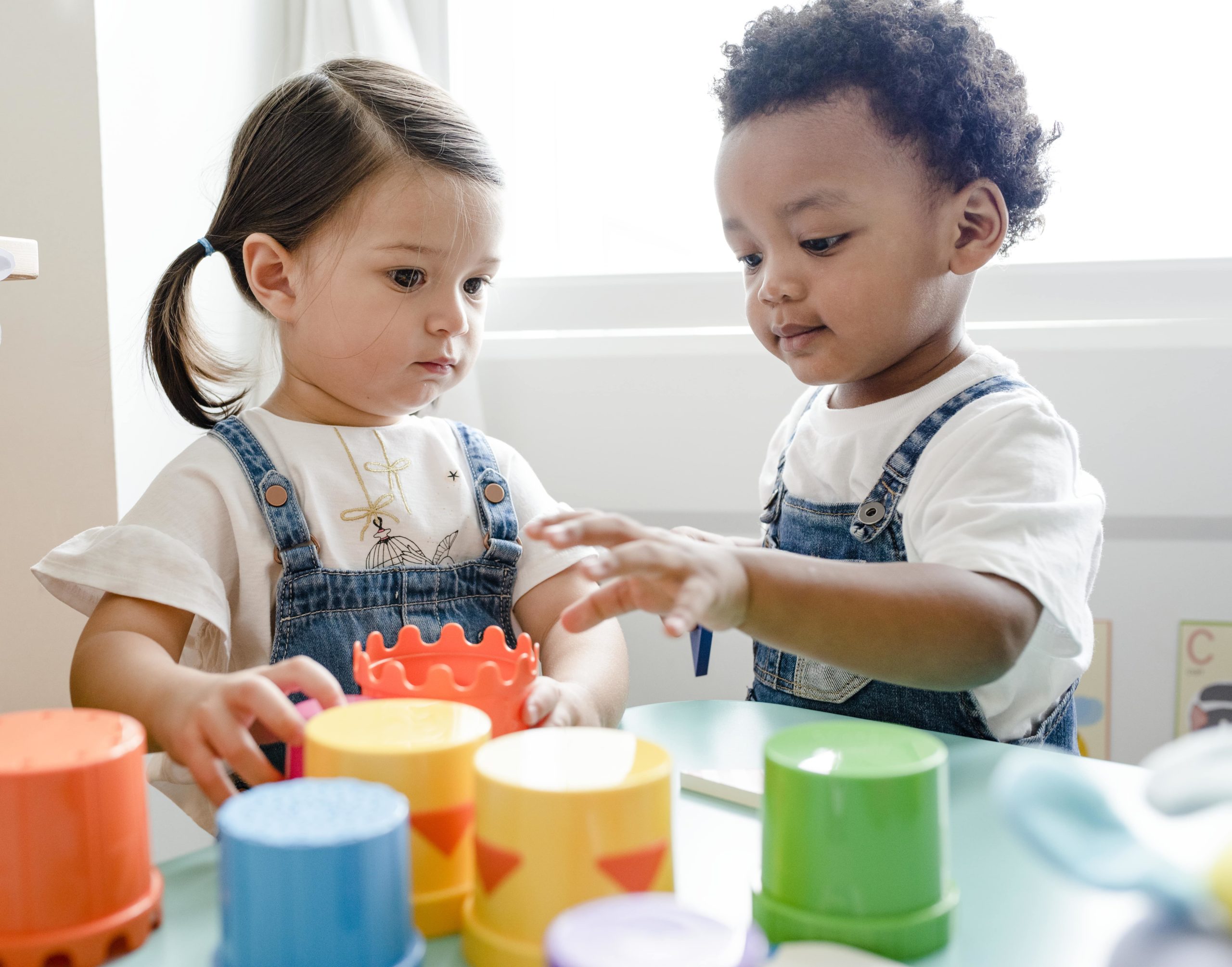 little-kids-playing-toys-learning-center-min